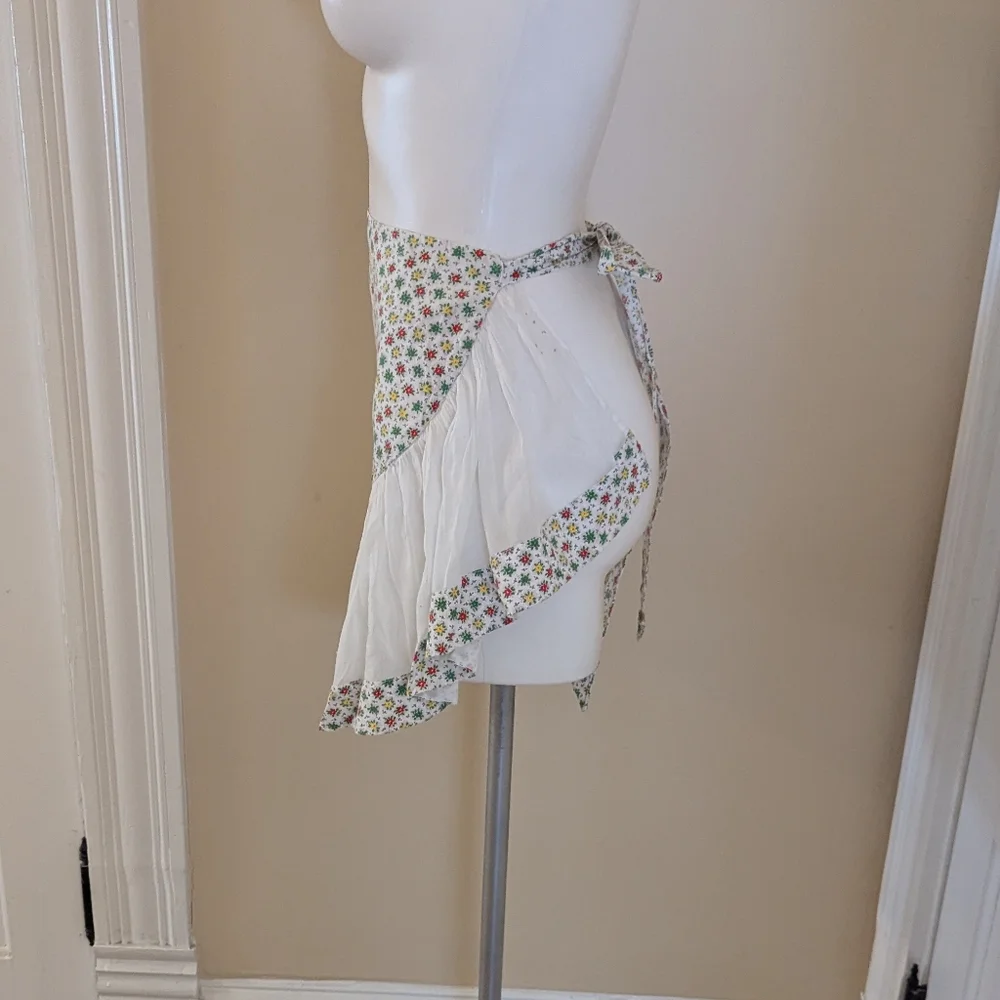 Vintage handmade white apron with red, green and red floral print.